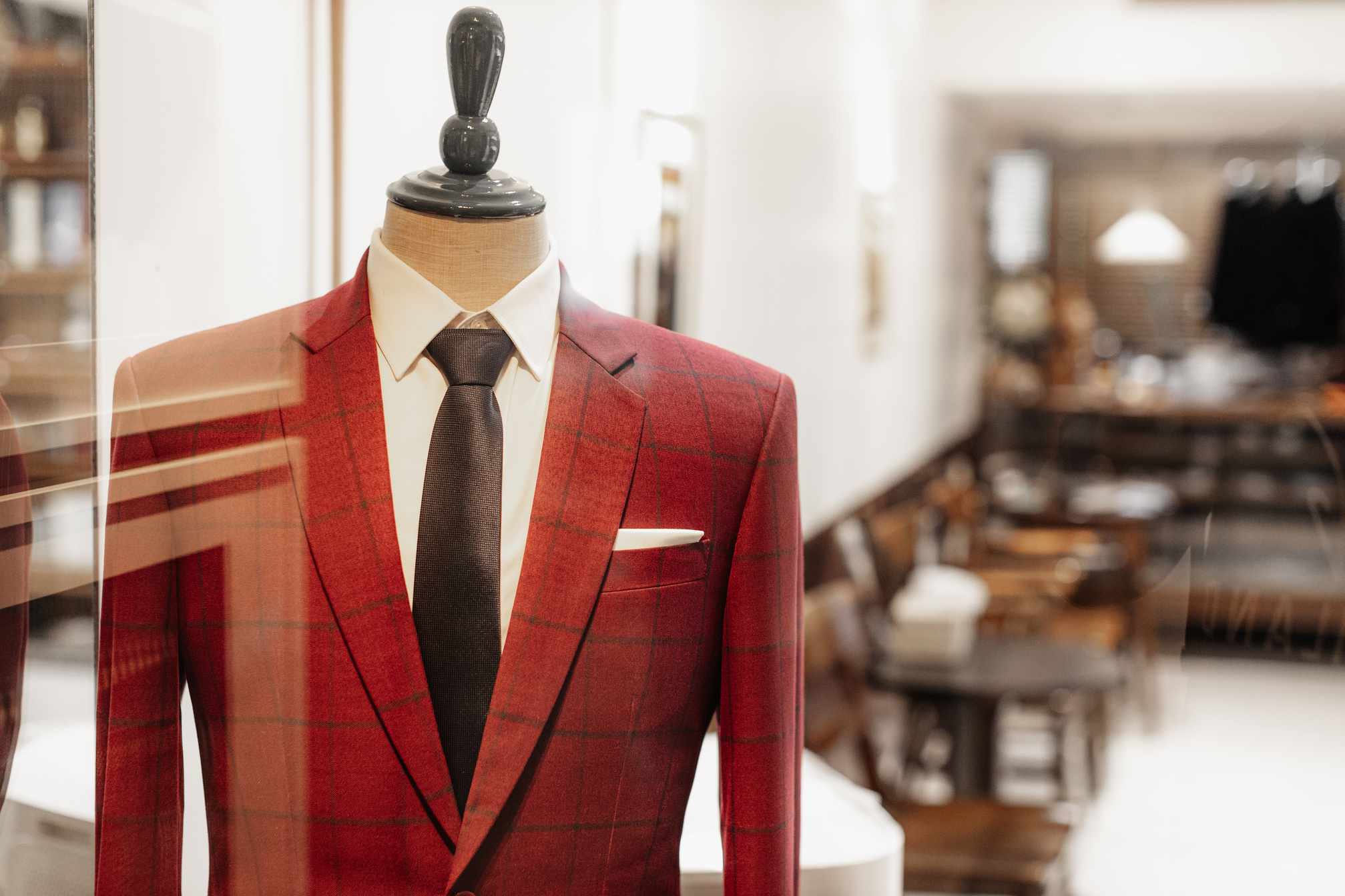 red suit at tailor storefront. gentleman clothes on mannequin display at suit cut bespoke tailor.